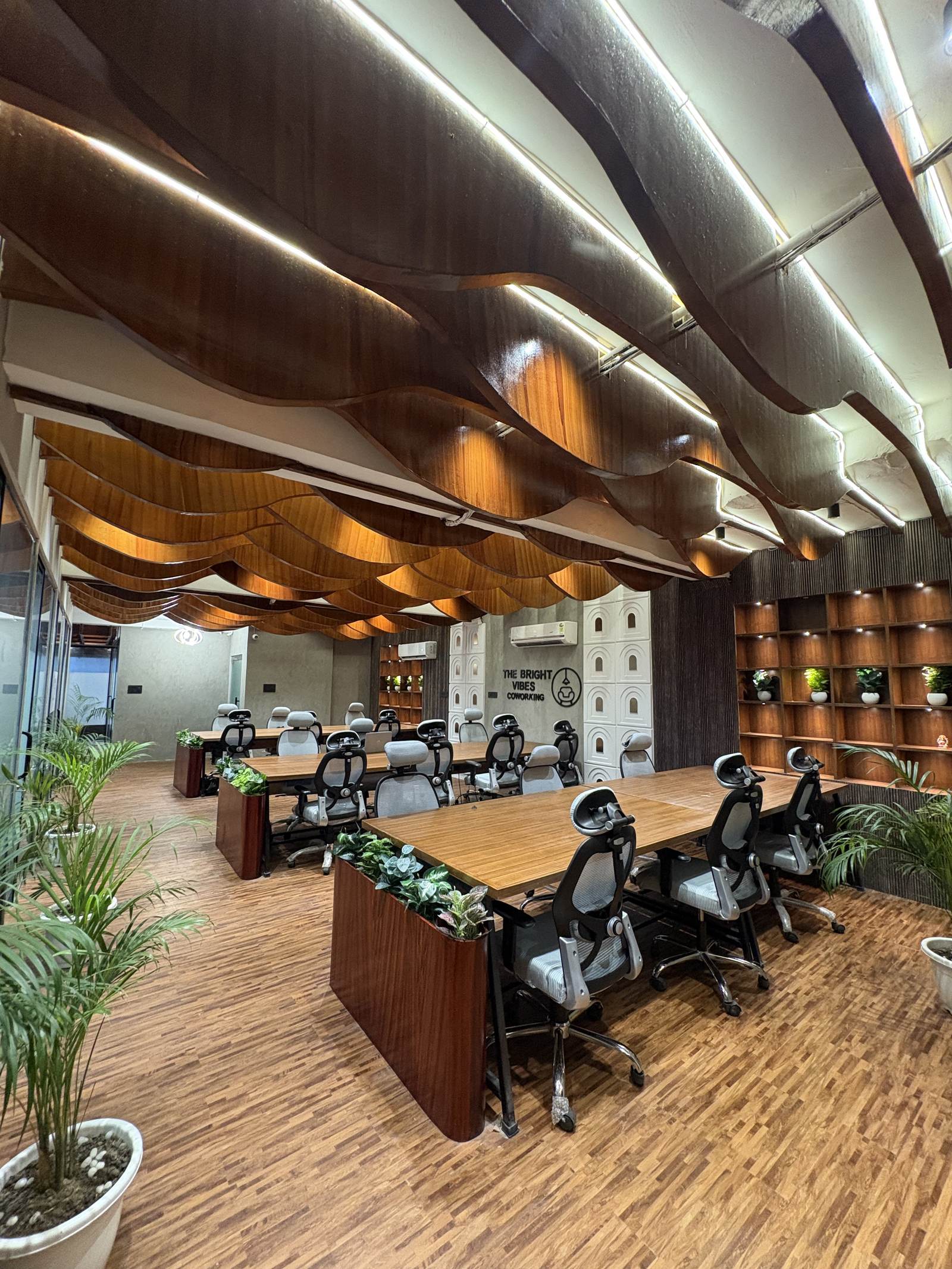 Sculptural wood-slat ceiling and open desking at The Bright Vibes Coworking, Hargobind Enclave